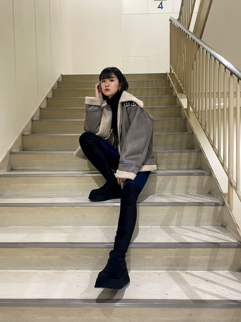 ブルー系のデニムパンツ、グレー系のブルゾン、ブラック系のニット/セーターを着用したレディースの冬コーディネートの3枚目の写真