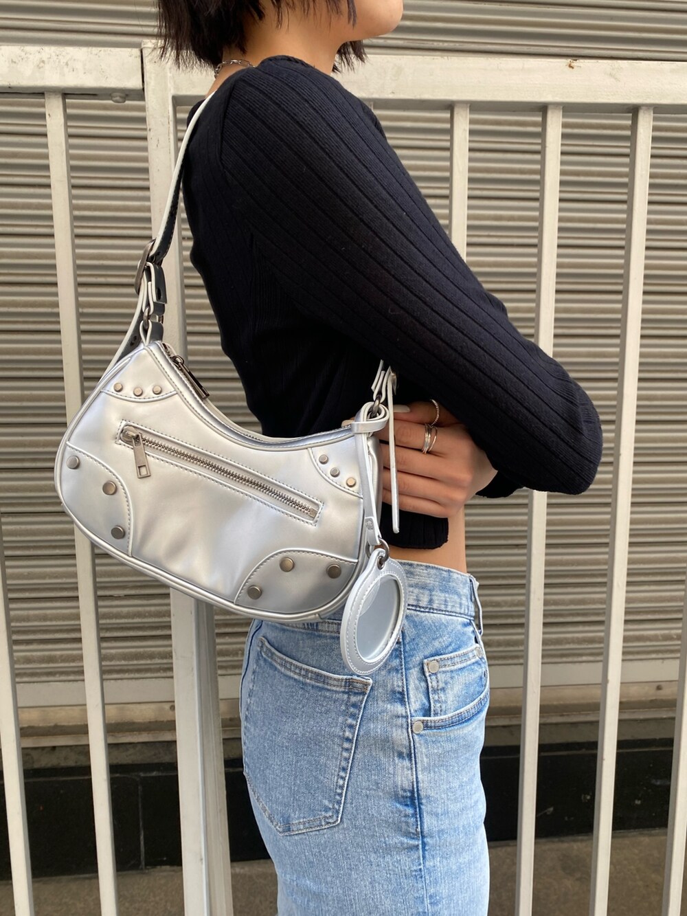 ブルー系のデニムパンツ、ブラック系のTシャツ/カットソー、シルバー系のハンドバッグを着用したレディースの春コーディネートの9枚目の写真