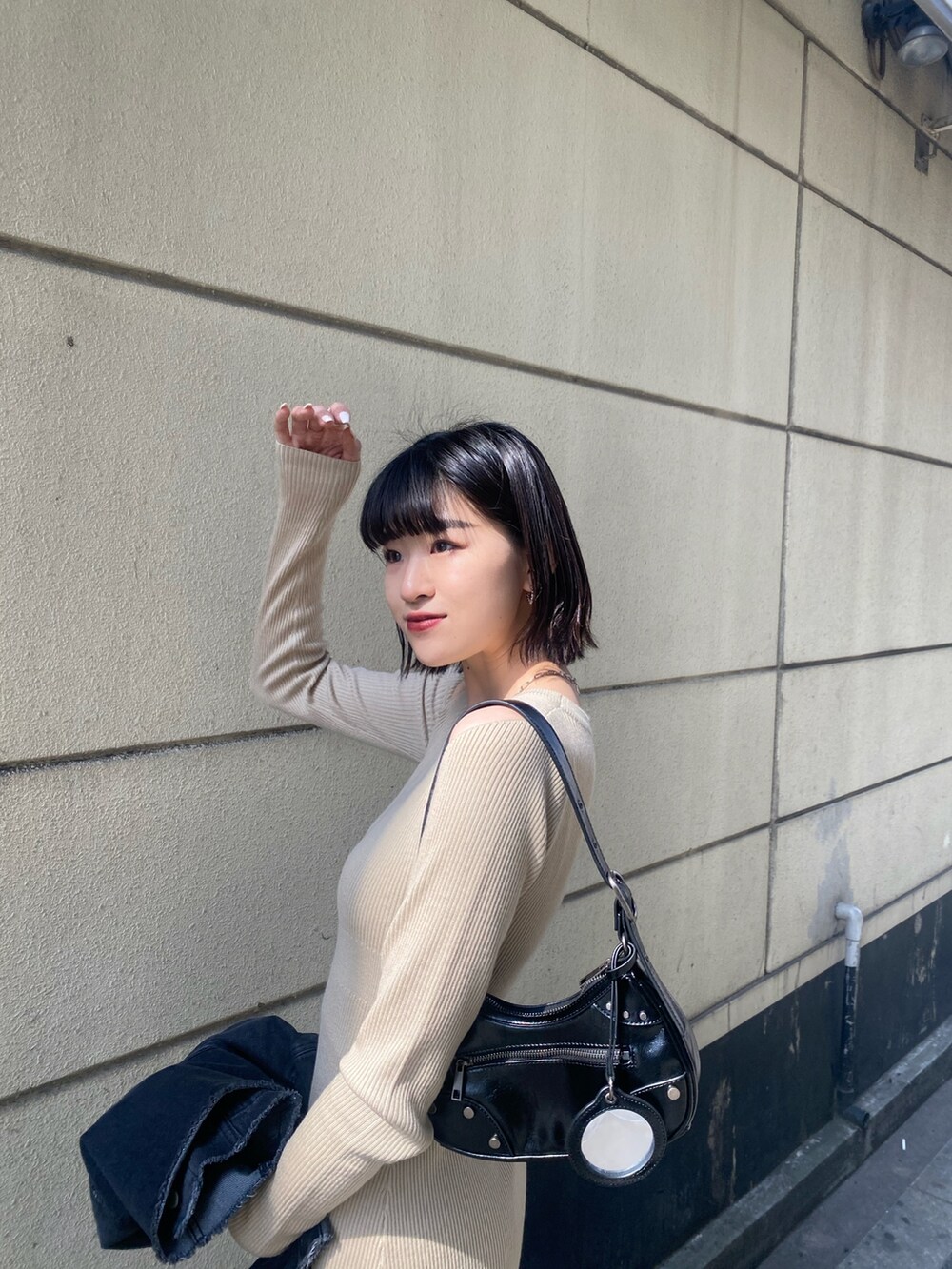 ブラック系のブーツ、ベージュ系のワンピース、ブラック系のデニムジャケットを着用したレディースの春コーディネートの5枚目の写真