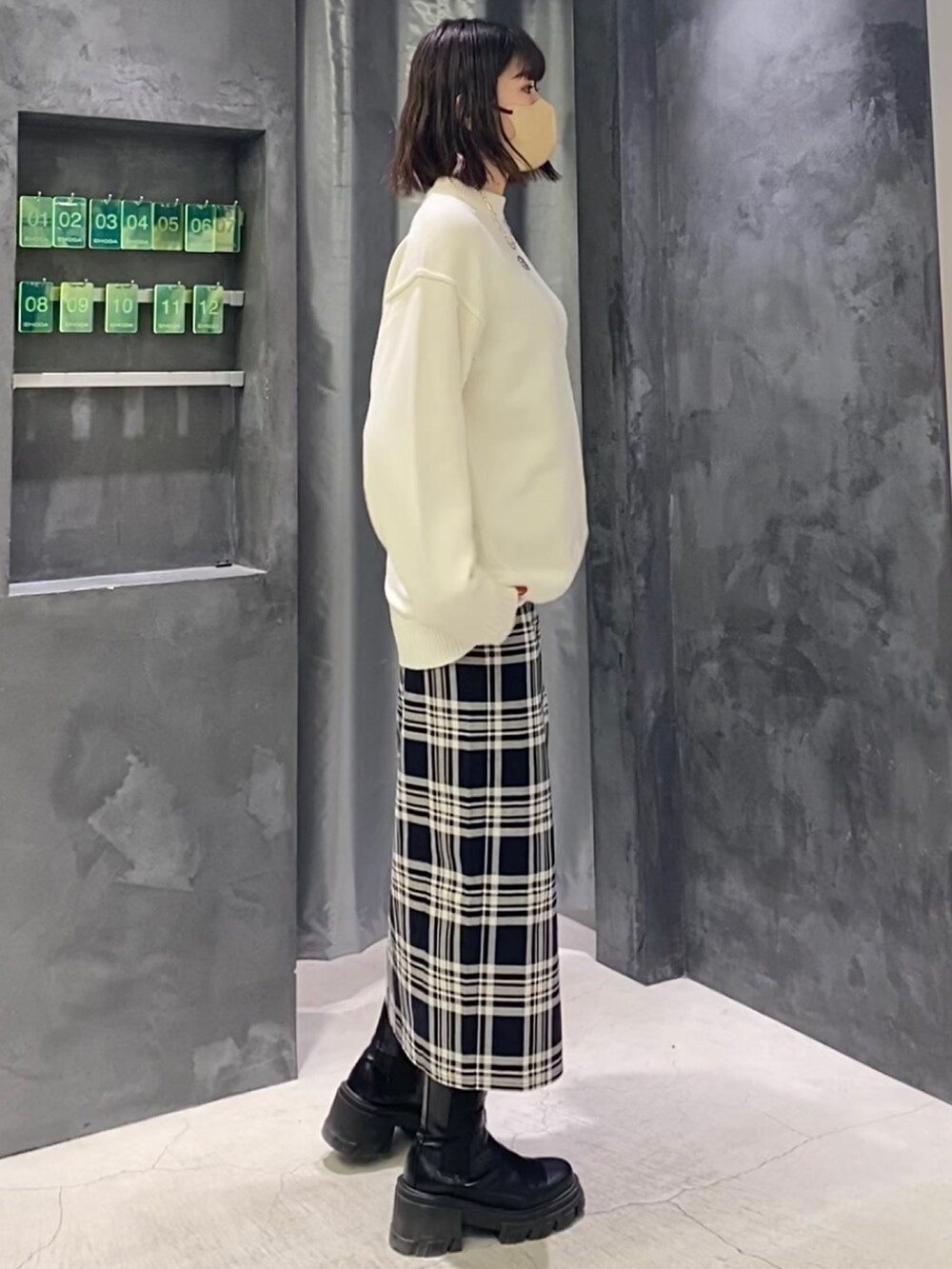 その他のスカート、ホワイト系のニット/セーター、ブラック系のブーツを着用したレディースの冬コーディネートの6枚目の写真