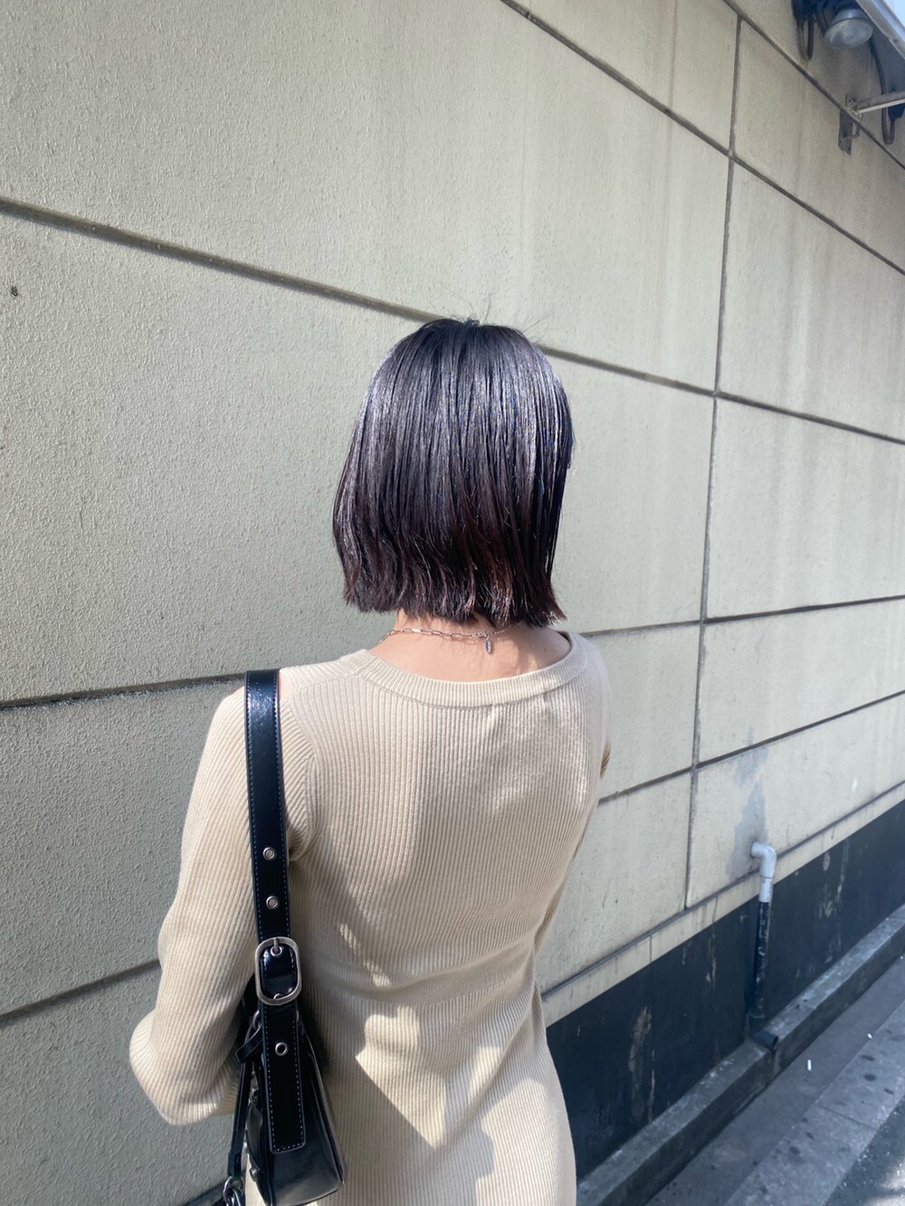 ブラック系のブーツ、ベージュ系のワンピース、ブラック系のデニムジャケットを着用したレディースの春コーディネートの7枚目の写真