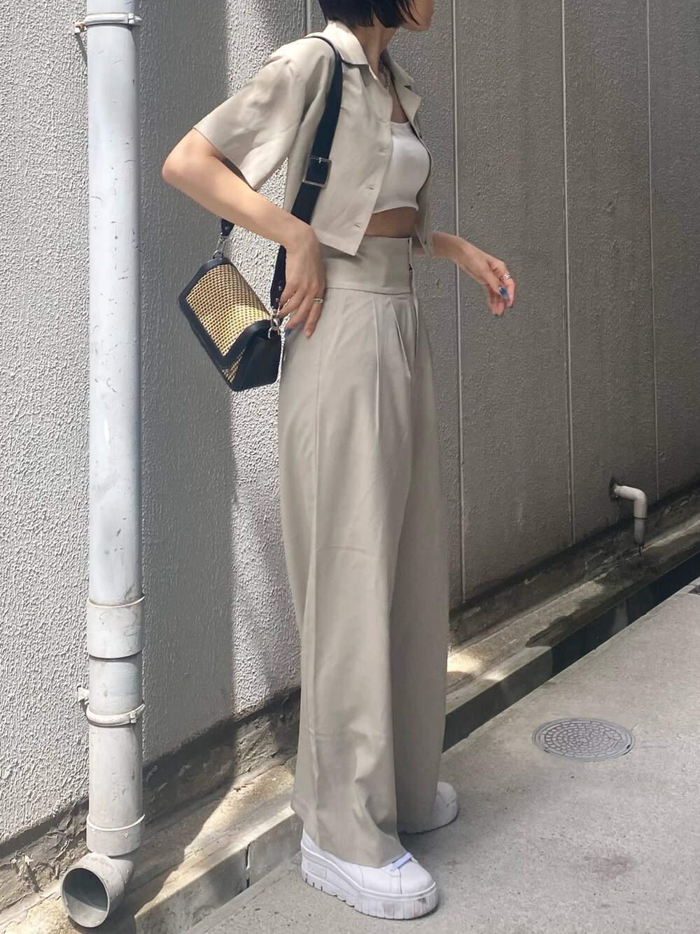 ベージュ系のその他パンツ、ホワイト系のキャミソール、ベージュ系のショルダーバッグを着用したレディースの夏コーディネートの4枚目の写真