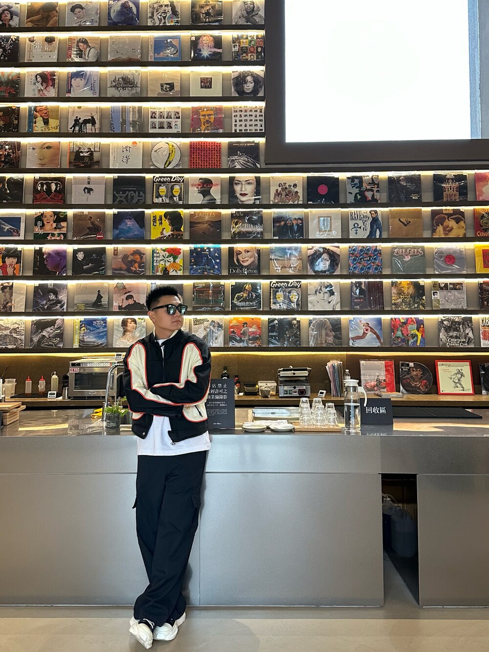 ブラック系のナイロンジャケット、ブラック系のパンツ、ブラック系のシューズを着用したメンズの春コーディネートの2枚目の写真