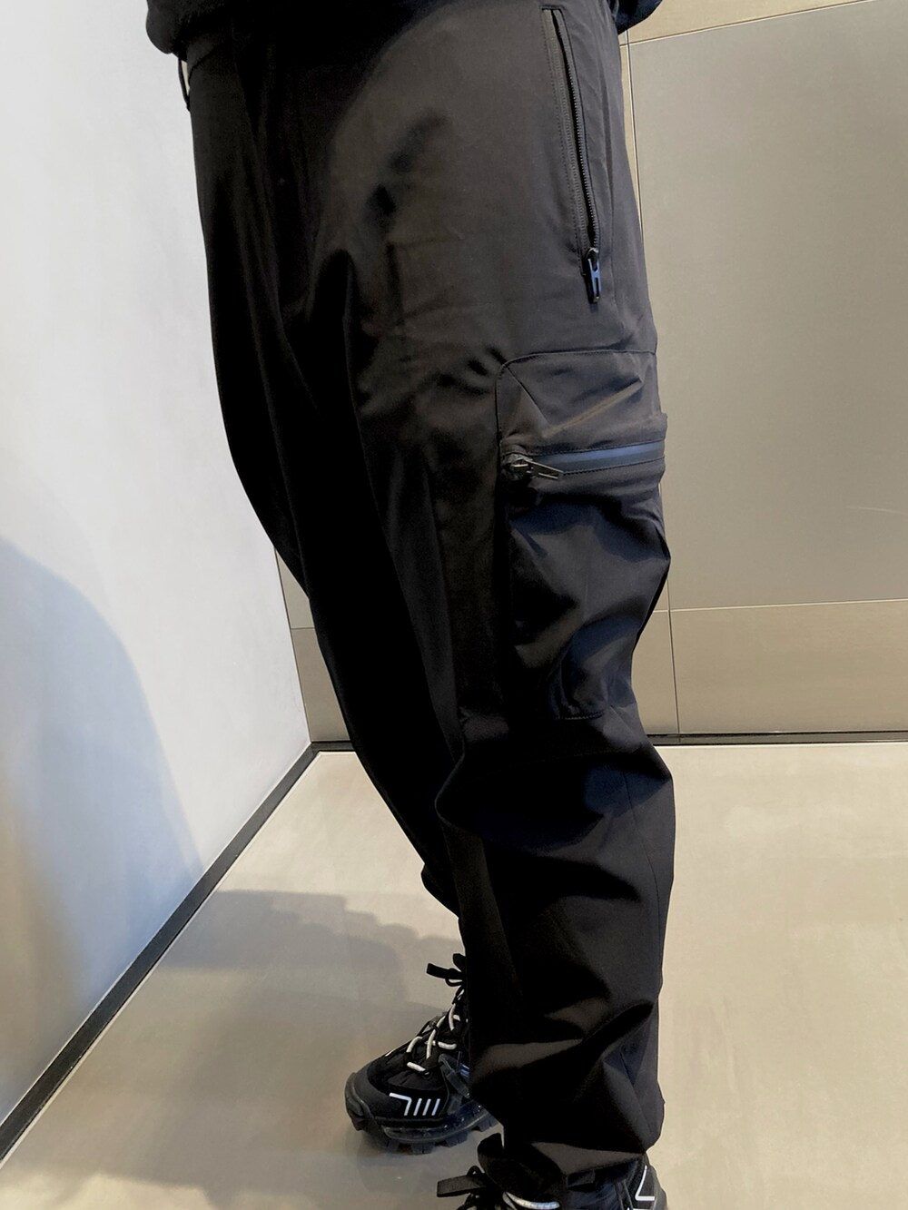 ブラック系のパーカー、ブラック系のカーゴパンツ、ブラック系のスニーカーを着用したメンズの冬コーディネートの4枚目の写真