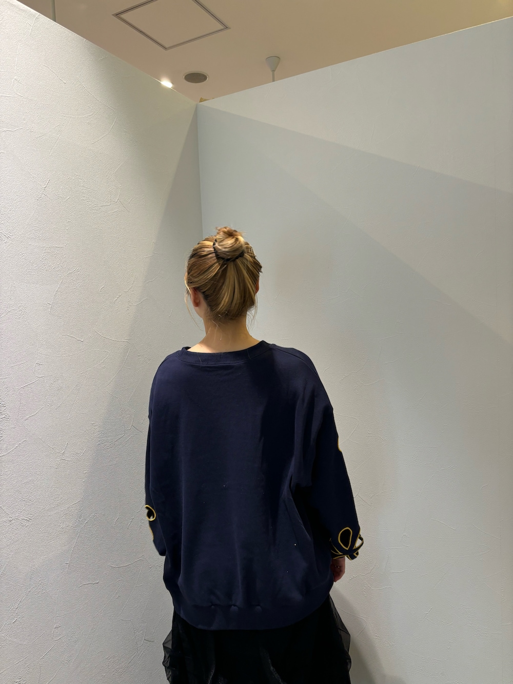 ブルー系のTシャツ/カットソー、ブラック系のスカート、ブルー系のデニムパンツを着用したレディースの秋コーディネートの3枚目の写真