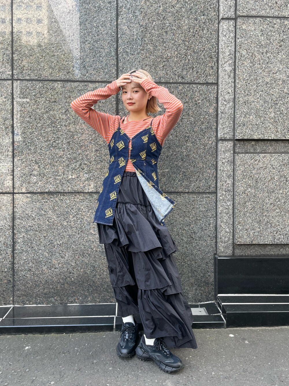 ブルー系のキャミソール、オレンジ系のTシャツ/カットソー、ブラック系のスカートを着用したレディースの夏コーディネートの2枚目の写真