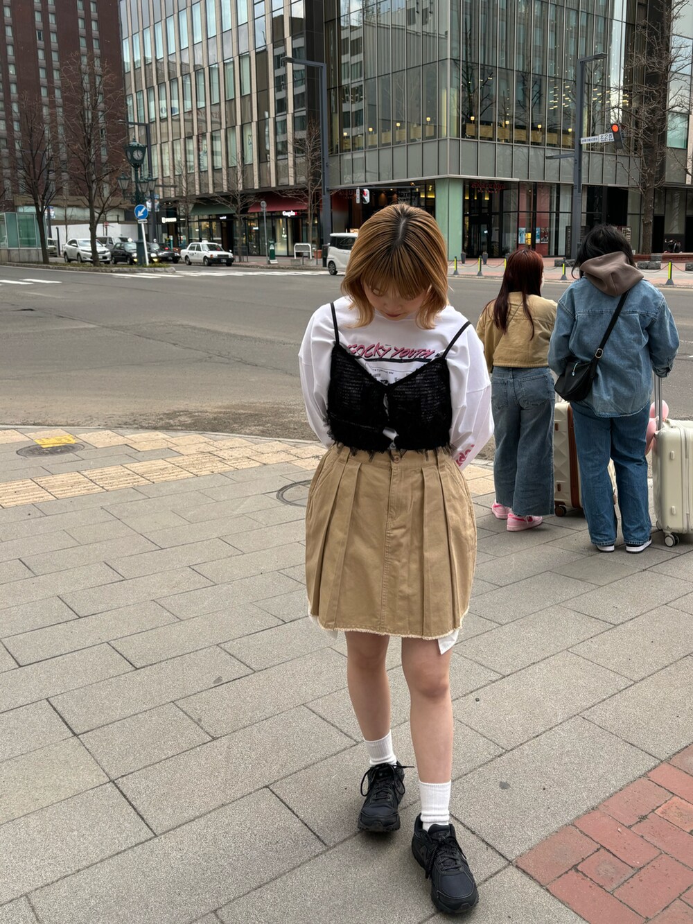 ベージュ系のスカート、オレンジ系のキャミソール、ホワイト系のTシャツ/カットソーを着用したレディースの春コーディネートの2枚目の写真