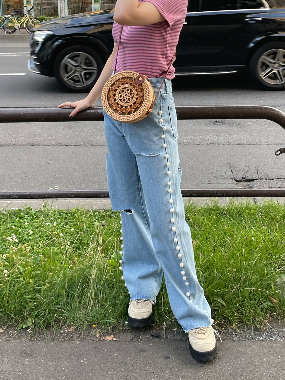 ブルー系のデニムパンツ、ベージュ系のかごバッグを着用したレディースの夏コーディネートの2枚目の写真