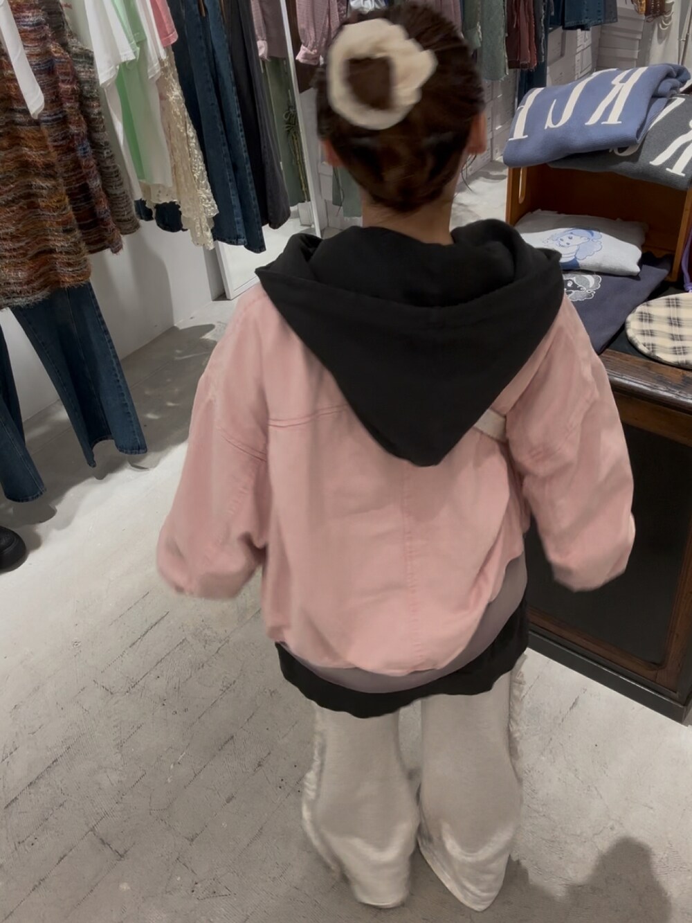 ホワイト系のショルダーバッグ、ピンク系のブルゾン、ブラック系のパーカーを着用したレディースの秋コーディネートの2枚目の写真