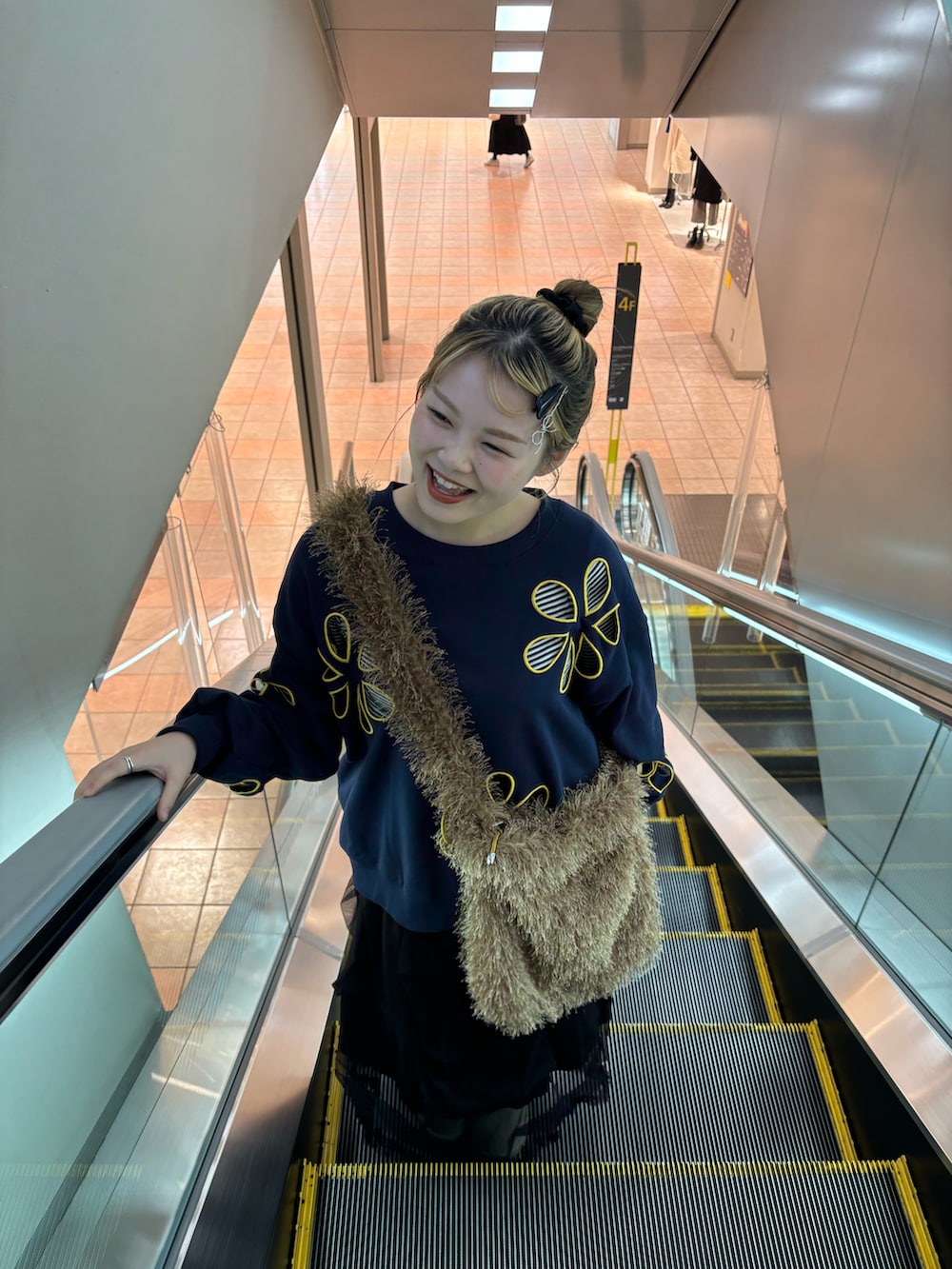 ブルー系のTシャツ/カットソー、ブラック系のスカート、ブルー系のデニムパンツを着用したレディースの秋コーディネートの2枚目の写真