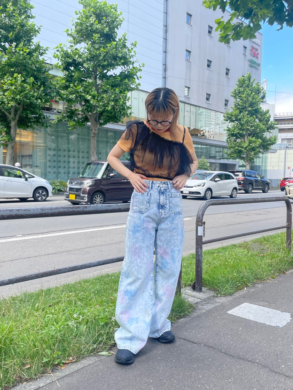 ブラック系のその他トップス、オレンジ系のワンピース、ブルー系のデニムパンツを着用したレディースの夏コーディネートの3枚目の写真