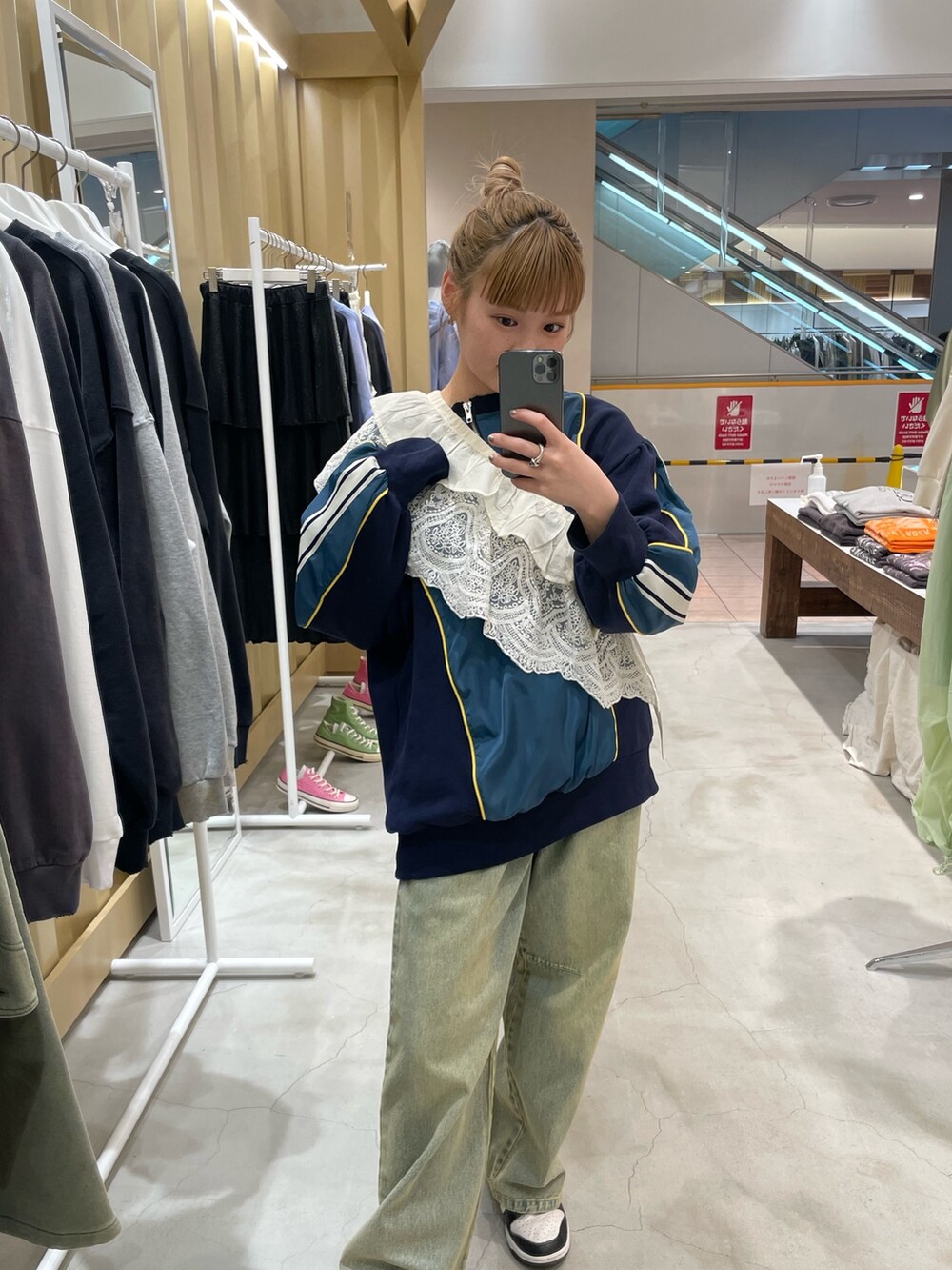 ブルー系のスウェット、ブルー系のデニムパンツ、ホワイト系の付け襟を着用したレディースの春コーディネートの2枚目の写真