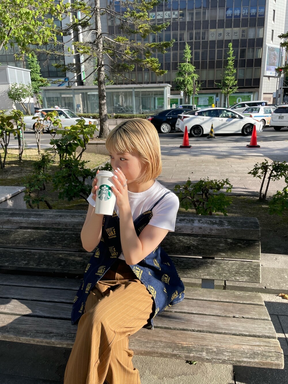 ブラウン系のスラックス、ブルー系のキャミソールを着用したレディースの夏コーディネートの5枚目の写真