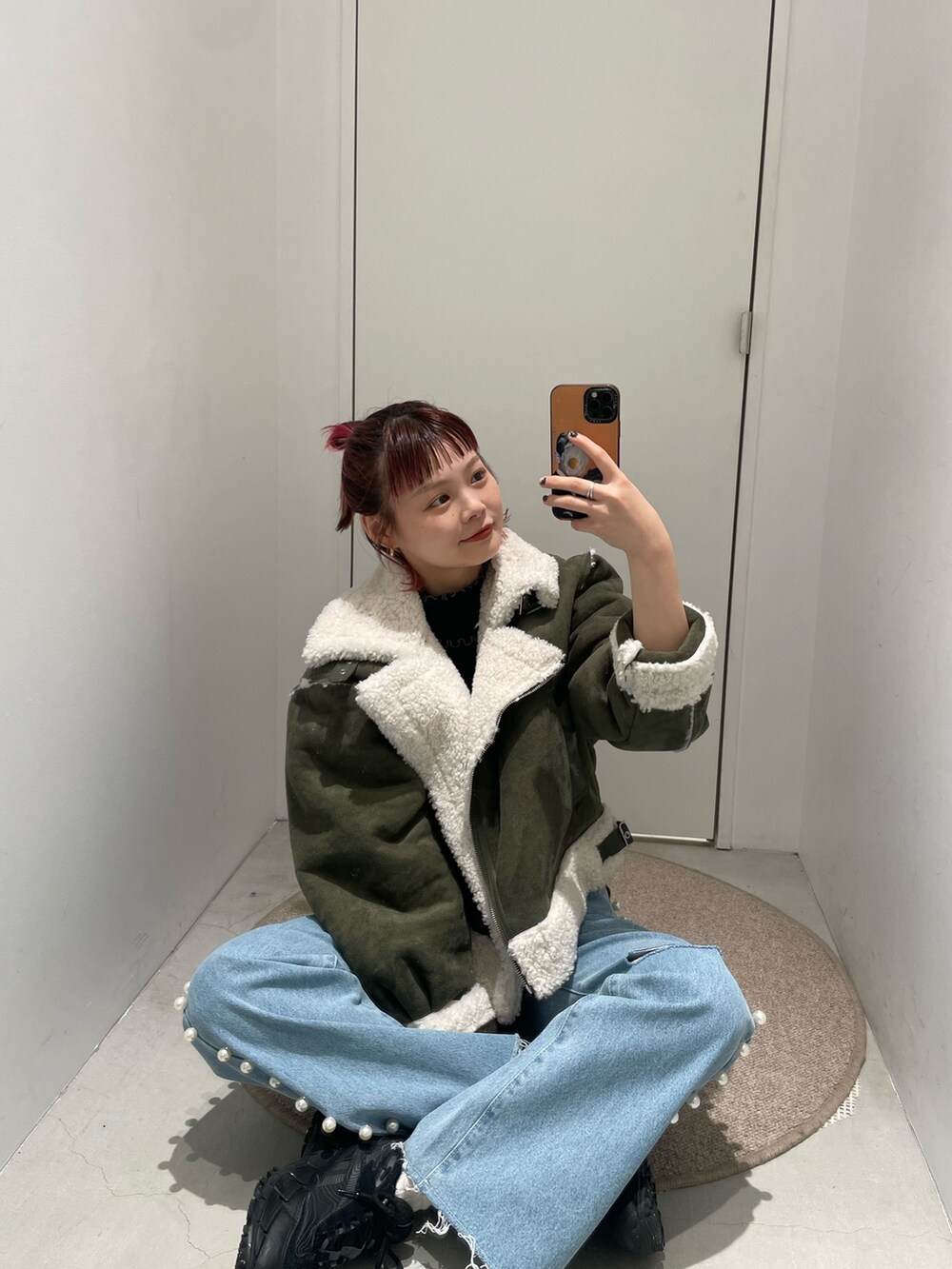 ホワイト系のムートンコート、ブルー系のデニムパンツを着用したレディースの冬コーディネートの2枚目の写真