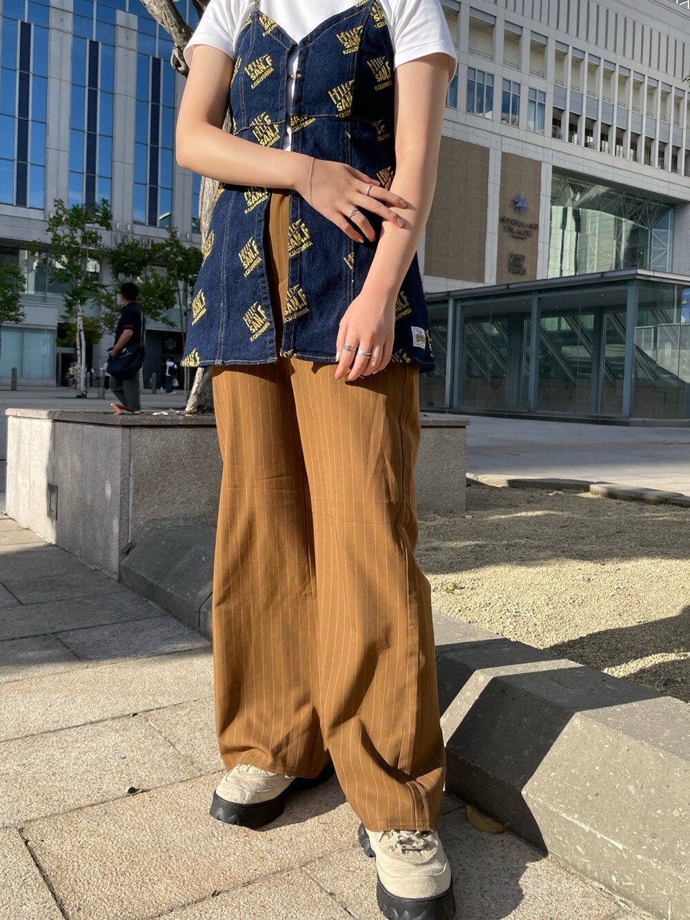 ブラウン系のスラックス、ブルー系のキャミソールを着用したレディースの夏コーディネートの2枚目の写真