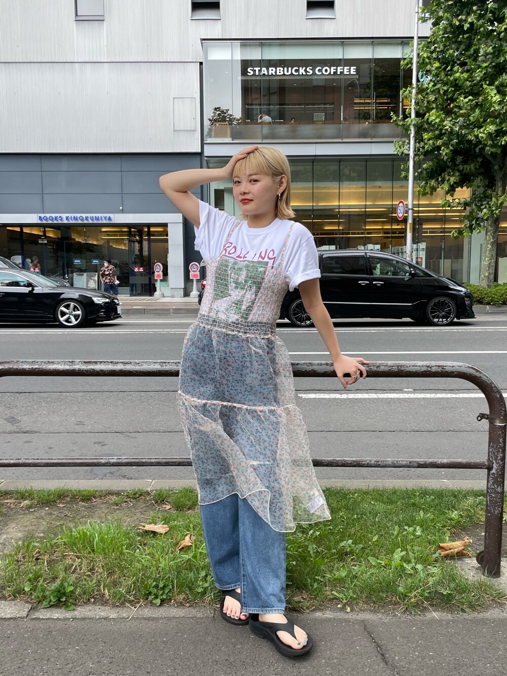 ベージュ系のワンピース、ホワイト系のTシャツ/カットソー、ブルー系のデニムパンツを着用したレディースの夏コーディネートの3枚目の写真