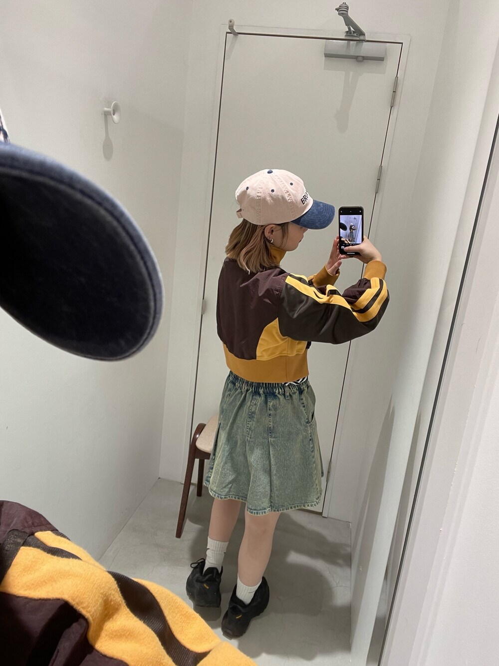 ブルー系のデニムスカート、ブラウン系のナイロンジャケット、ブラック系のTシャツ/カットソーを着用したレディースの冬コーディネートの3枚目の写真