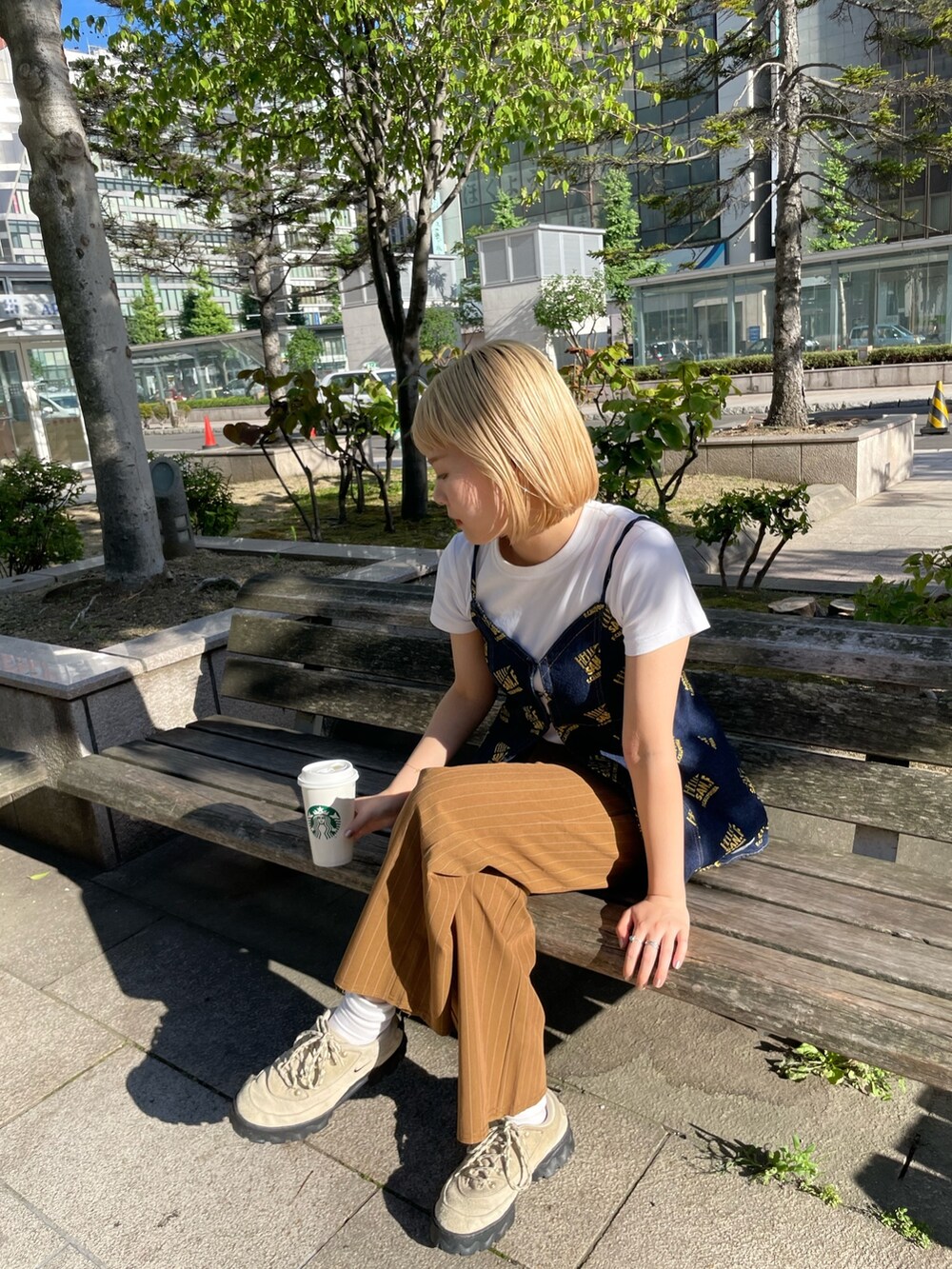 ブラウン系のスラックス、ブルー系のキャミソールを着用したレディースの夏コーディネートの4枚目の写真