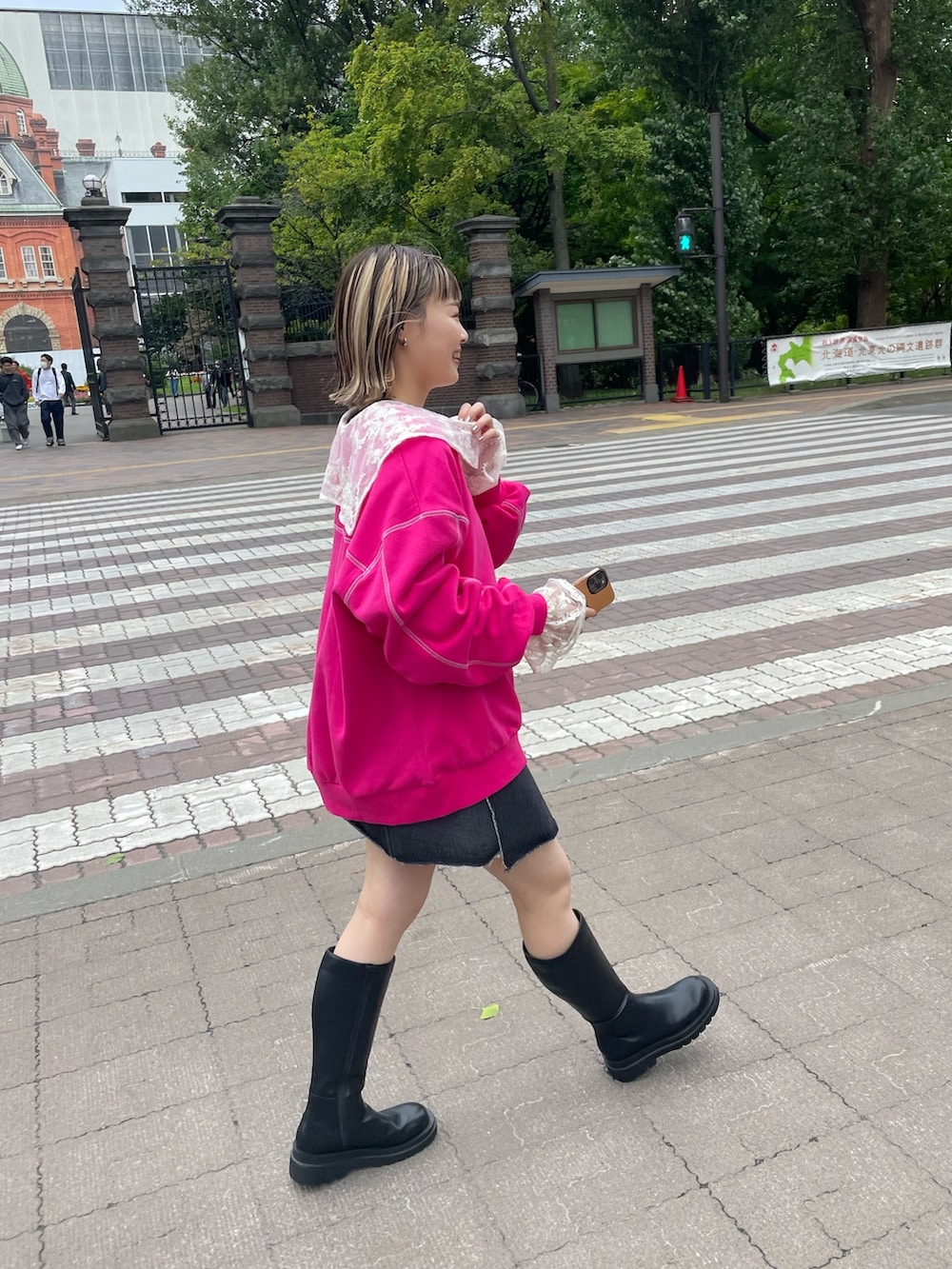 レッド系のスウェット、ホワイト系のシャツ/ブラウス、ブラック系のデニムスカートを着用したレディースの秋コーディネートの3枚目の写真