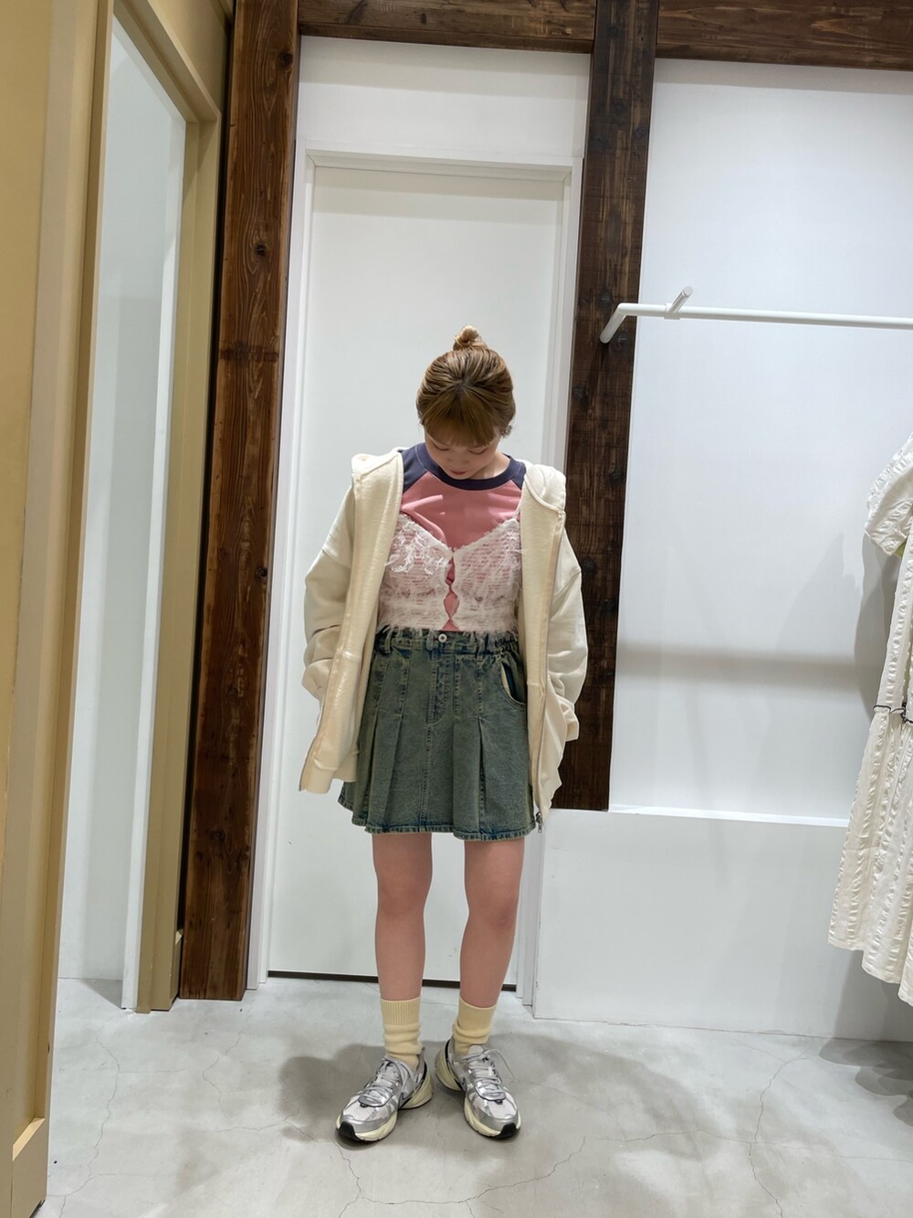 ホワイト系のパーカー、ホワイト系のキャミソール、ブルー系のデニムスカートを着用したレディースの春コーディネートの2枚目の写真