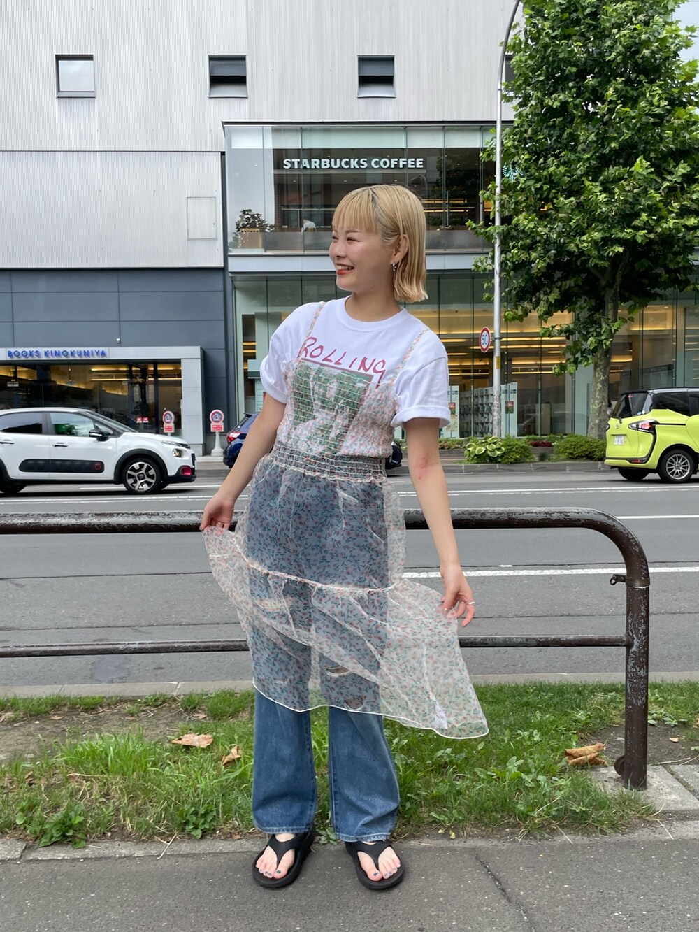 ベージュ系のワンピース、ホワイト系のTシャツ/カットソー、ブルー系のデニムパンツを着用したレディースの夏コーディネートの2枚目の写真