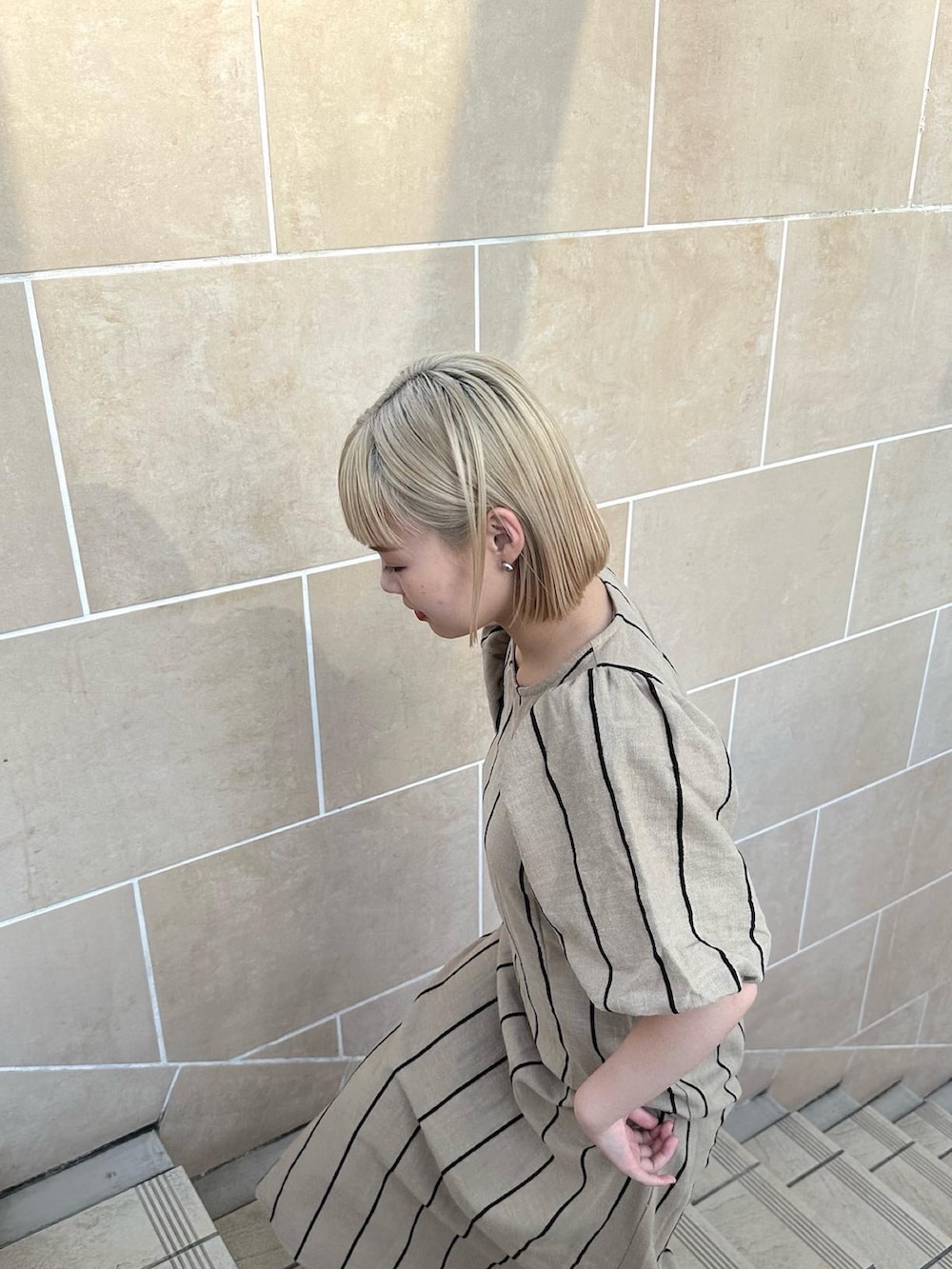 ベージュ系のワンピースを着用したレディースの夏コーディネートの2枚目の写真