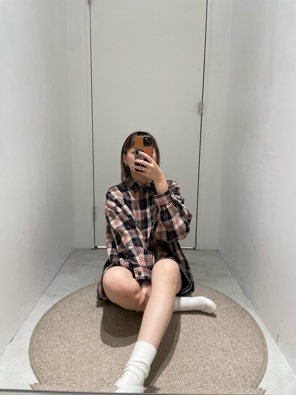 レッド系のシャツ/ブラウス、ブラック系のデニムスカートを着用したレディースの秋コーディネートの4枚目の写真