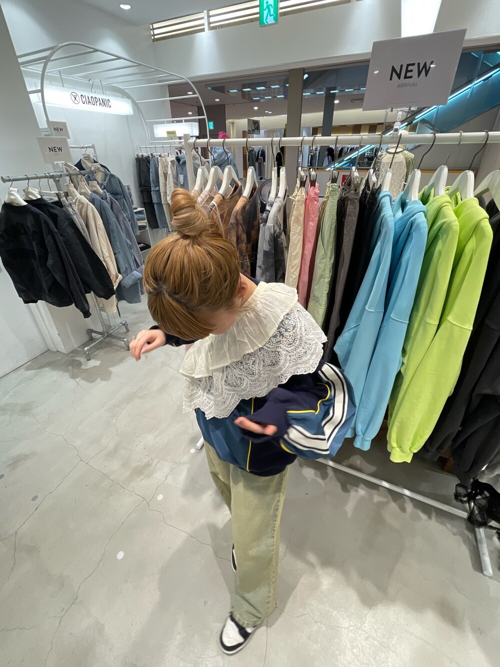 ブルー系のスウェット、ブルー系のデニムパンツ、ホワイト系の付け襟を着用したレディースの春コーディネートの4枚目の写真