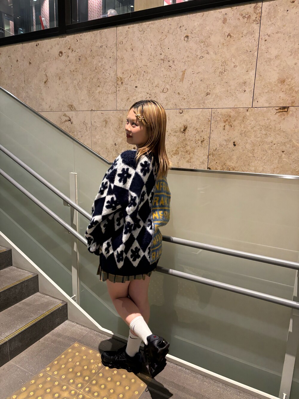 ブルー系のニット/セーター、ブラウン系のスカートを着用したレディースの秋コーディネートの2枚目の写真