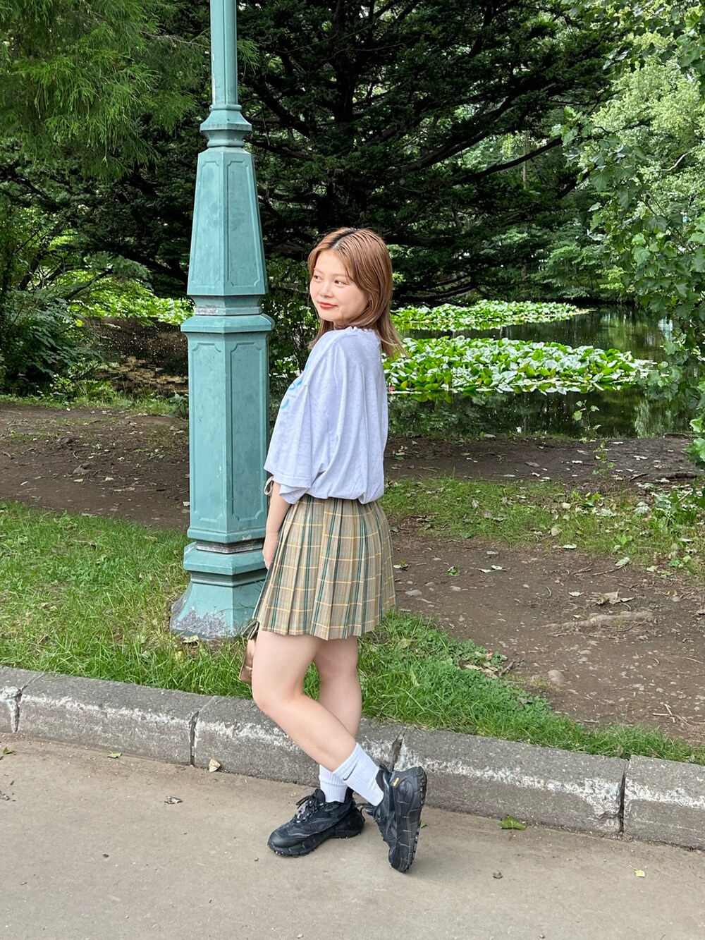 ブラウン系のスカート、ホワイト系のTシャツ/カットソーを着用したレディースの夏コーディネートの2枚目の写真