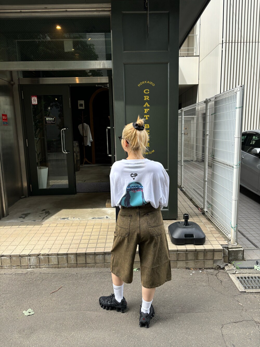 ホワイト系のTシャツ/カットソー、ブラウン系のデニムパンツを着用したレディースの夏コーディネートの2枚目の写真