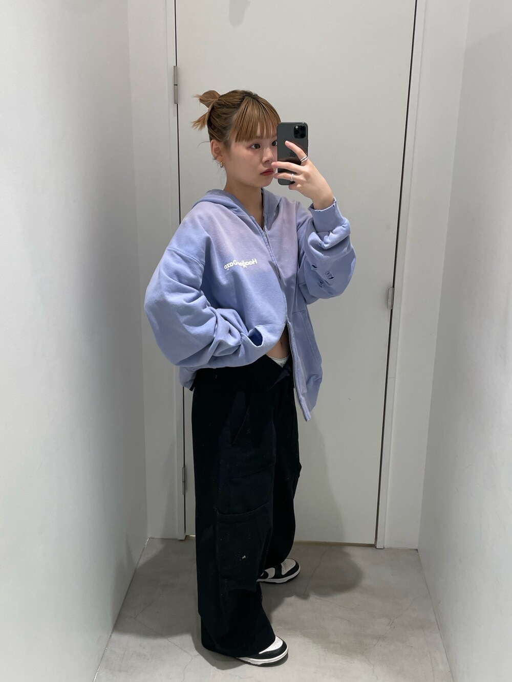 パープル系のパーカー、ブラック系のカーゴパンツを着用したレディースの春コーディネートの2枚目の写真