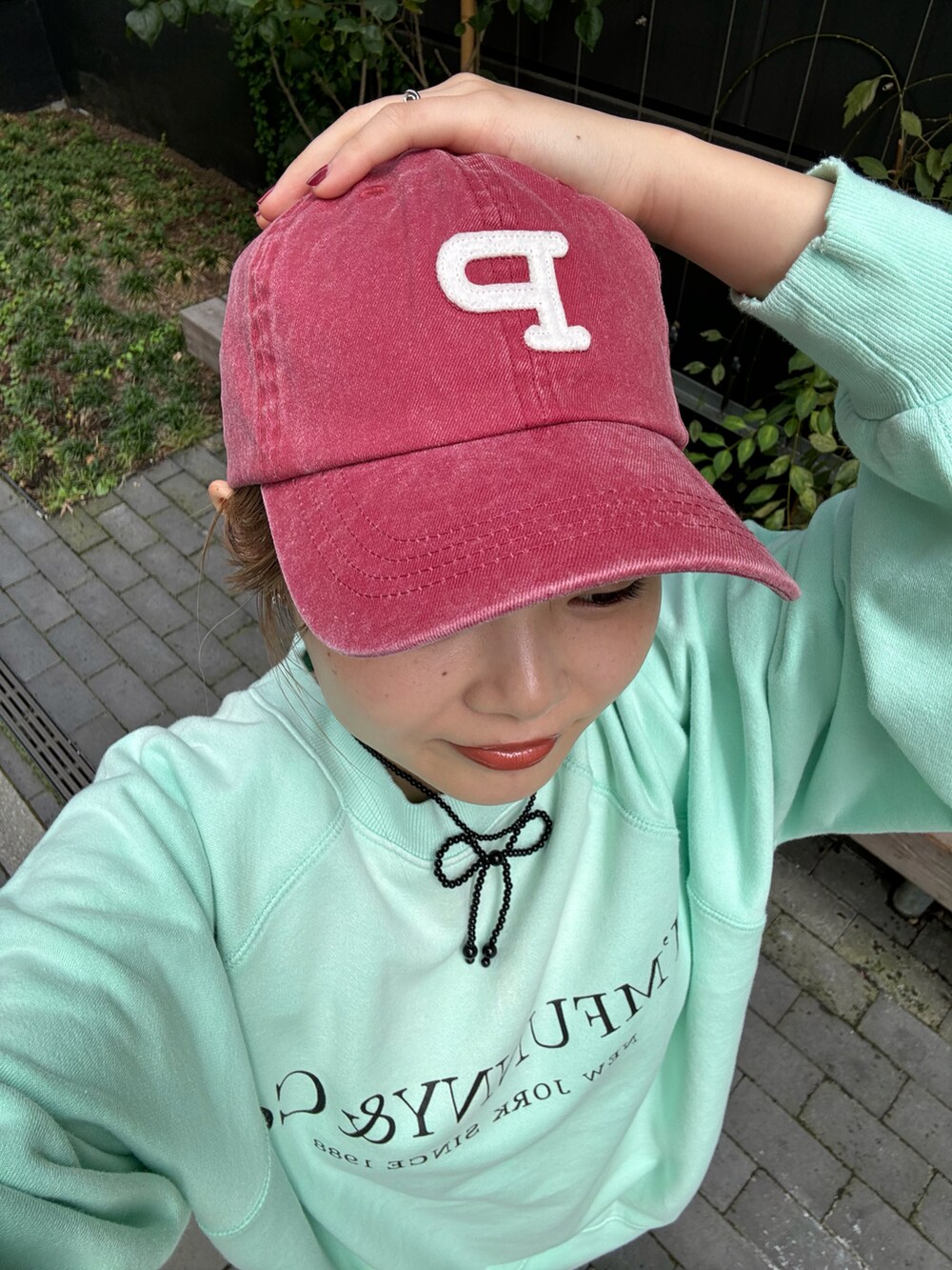 ブラック系のデニムパンツ、グリーン系のTシャツ/カットソー、ブラック系のネックレスを着用したレディースの秋コーディネートの4枚目の写真