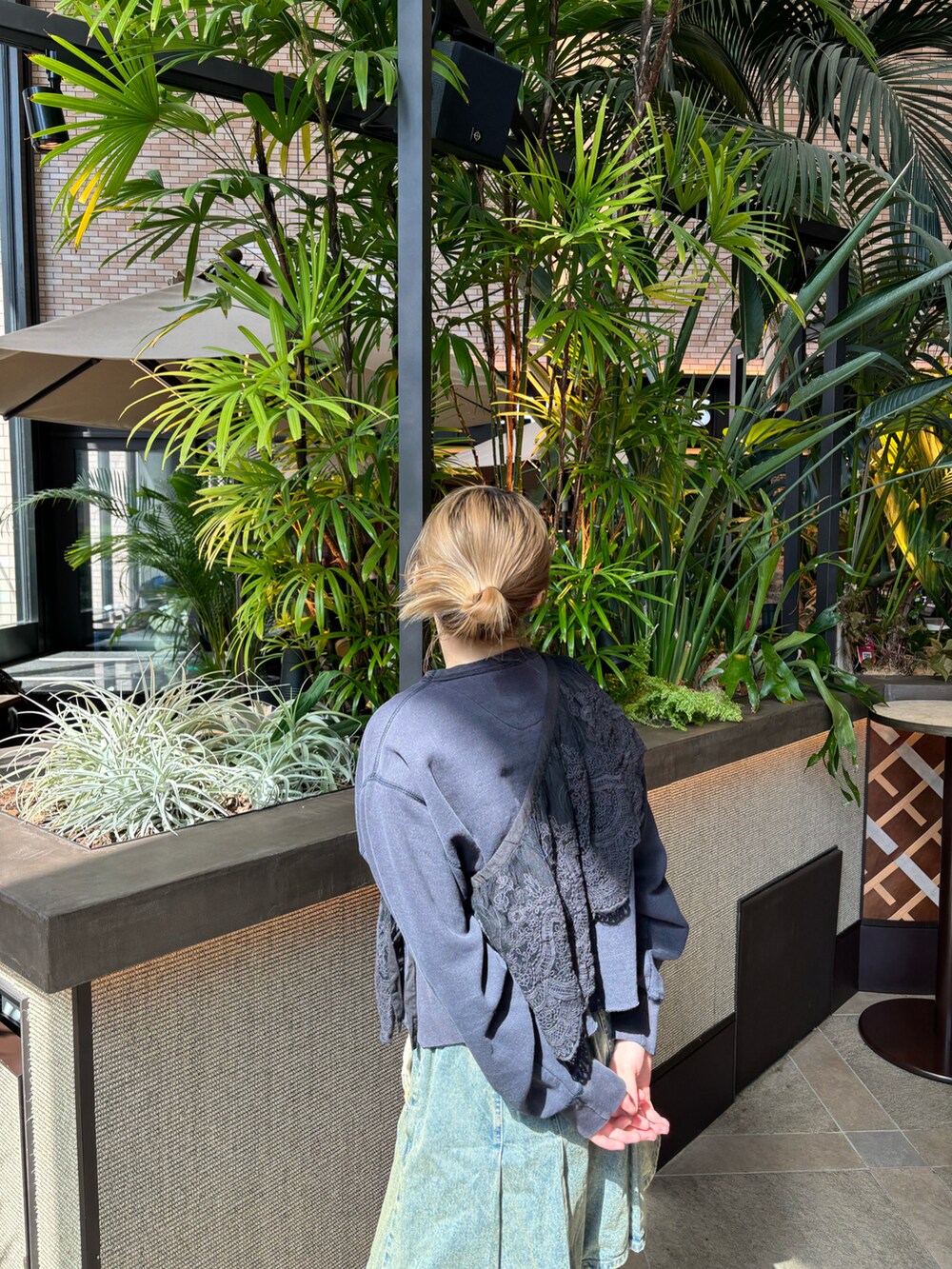 ブルー系のデニムスカート、ブラック系の付け襟を着用したレディースの春コーディネートの2枚目の写真