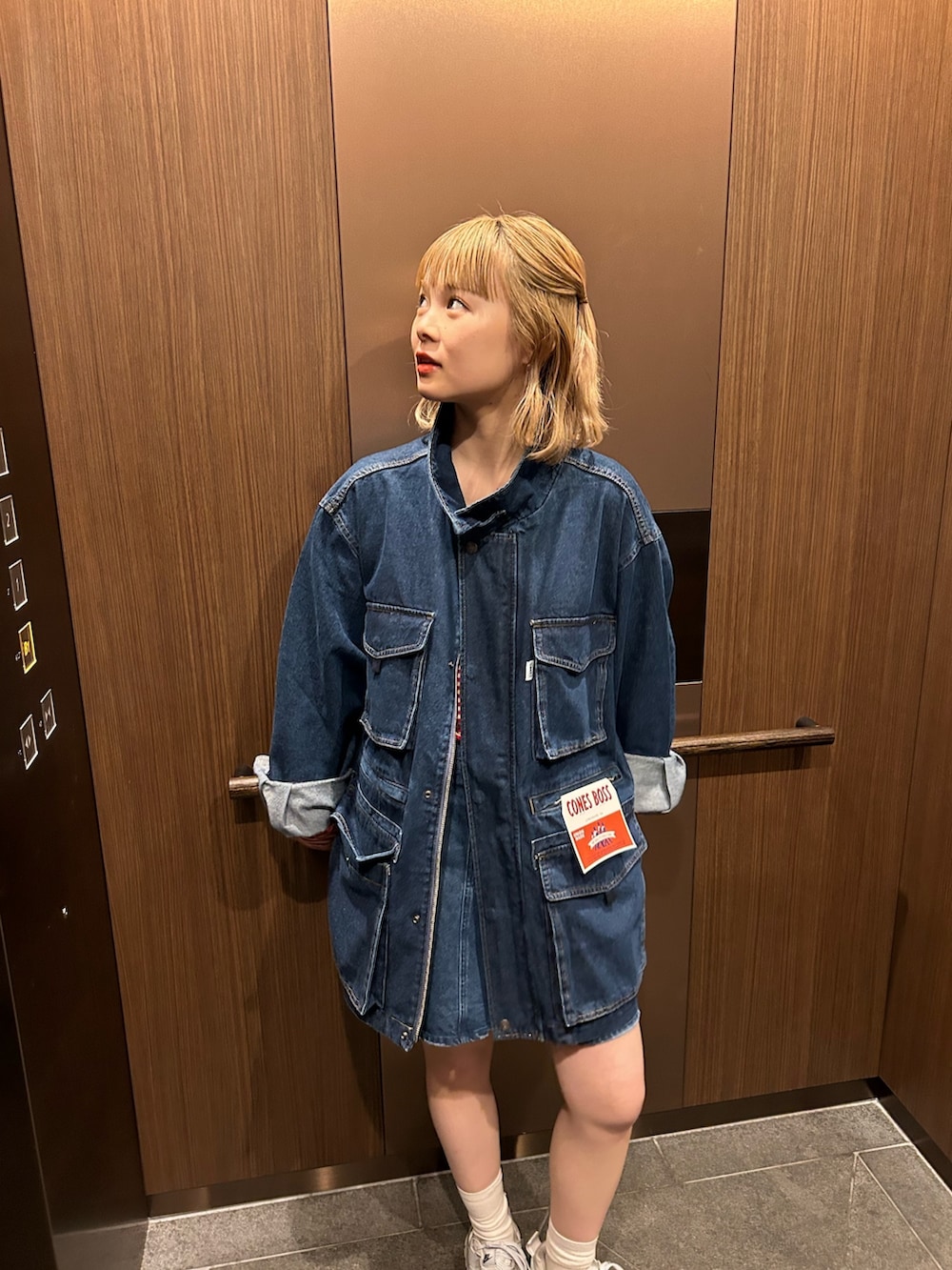 ブルー系のデニムジャケット、ブルー系のデニムスカート、レッド系のTシャツ/カットソーを着用したレディースの春コーディネートの2枚目の写真