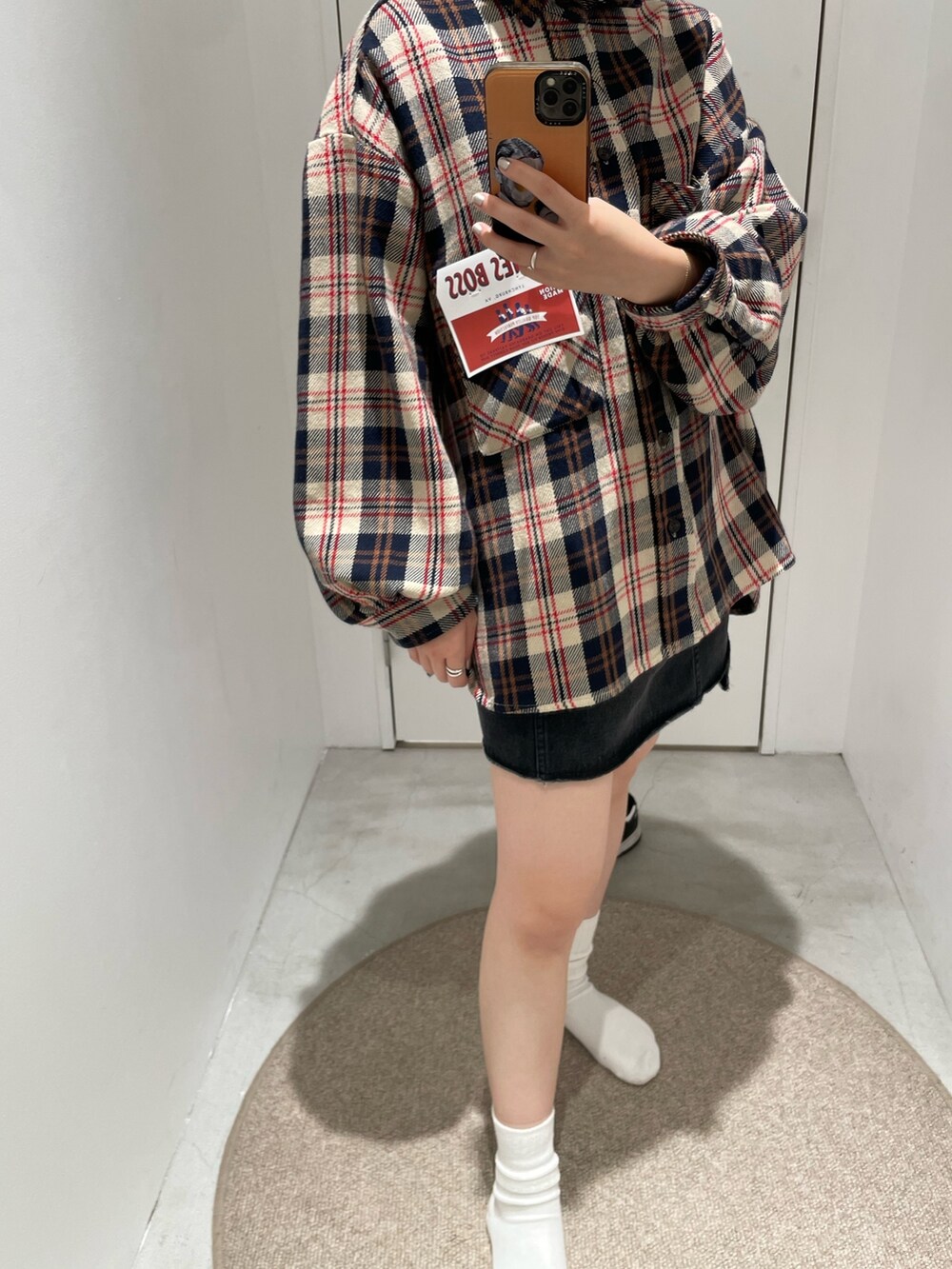 レッド系のシャツ/ブラウス、ブラック系のデニムスカートを着用したレディースの秋コーディネートの5枚目の写真