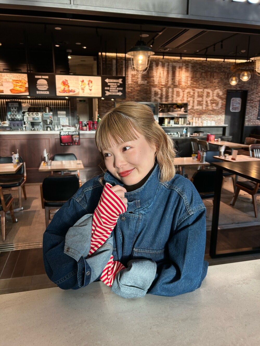 ブルー系のデニムジャケット、ブルー系のデニムスカート、レッド系のTシャツ/カットソーを着用したレディースの春コーディネートの5枚目の写真