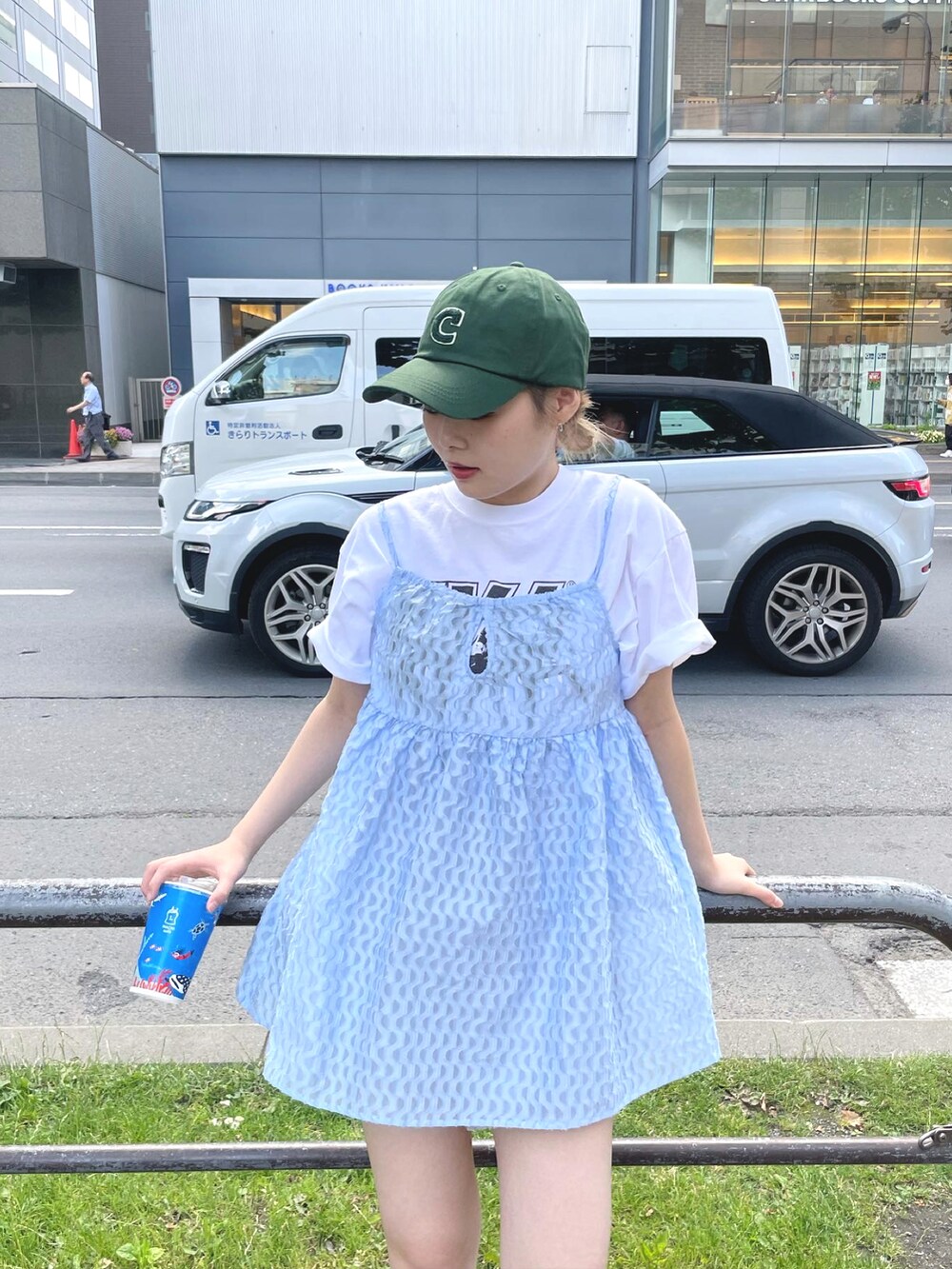 ブルー系のキャミソール、パープル系のパンツ、グリーン系のキャップを着用したレディースの夏コーディネートの2枚目の写真