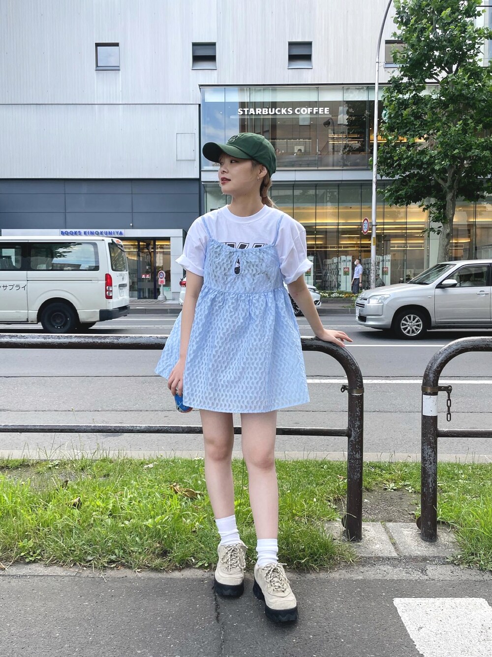 ブルー系のキャミソール、パープル系のパンツ、グリーン系のキャップを着用したレディースの夏コーディネートの3枚目の写真