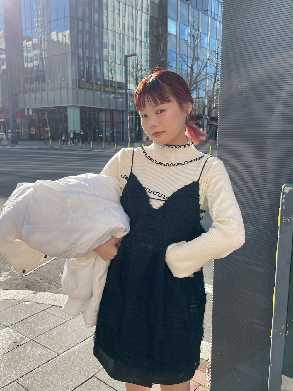 ブラック系のワンピース、ホワイト系のダウンジャケット/コート、ホワイト系のニット/セーターを着用したレディースの冬コーディネートの2枚目の写真