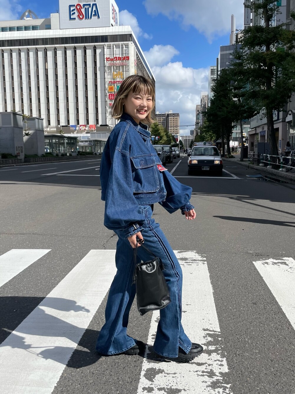 ブルー系のデニムパンツ、ブルー系のデニムジャケット、ブラウン系のTシャツ/カットソーを着用したレディースの秋コーディネートの4枚目の写真