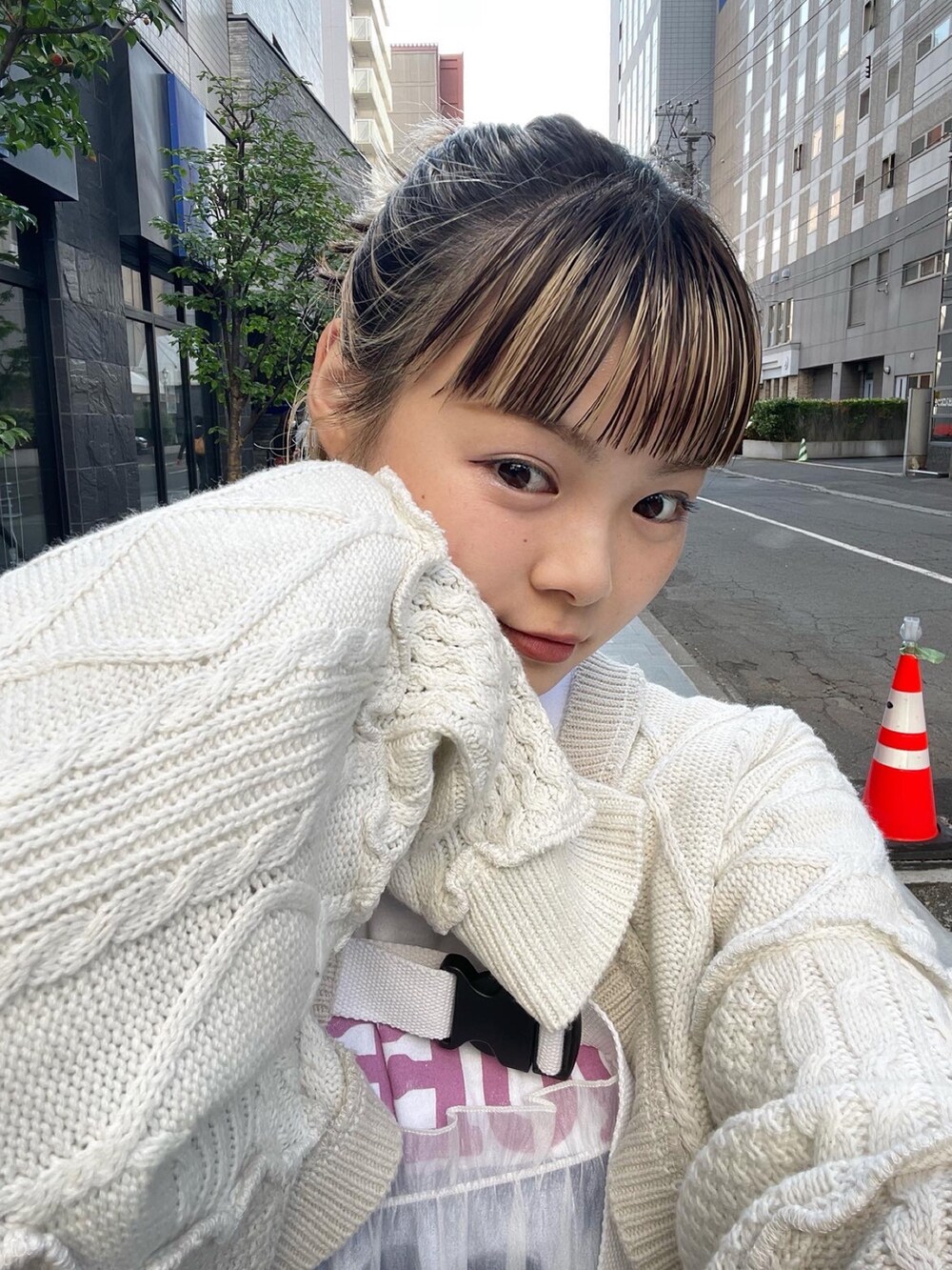 ホワイト系のワンピース、ホワイト系のカーディガン/ボレロ、ブラック系のデニムパンツを着用したレディースの秋コーディネートの5枚目の写真