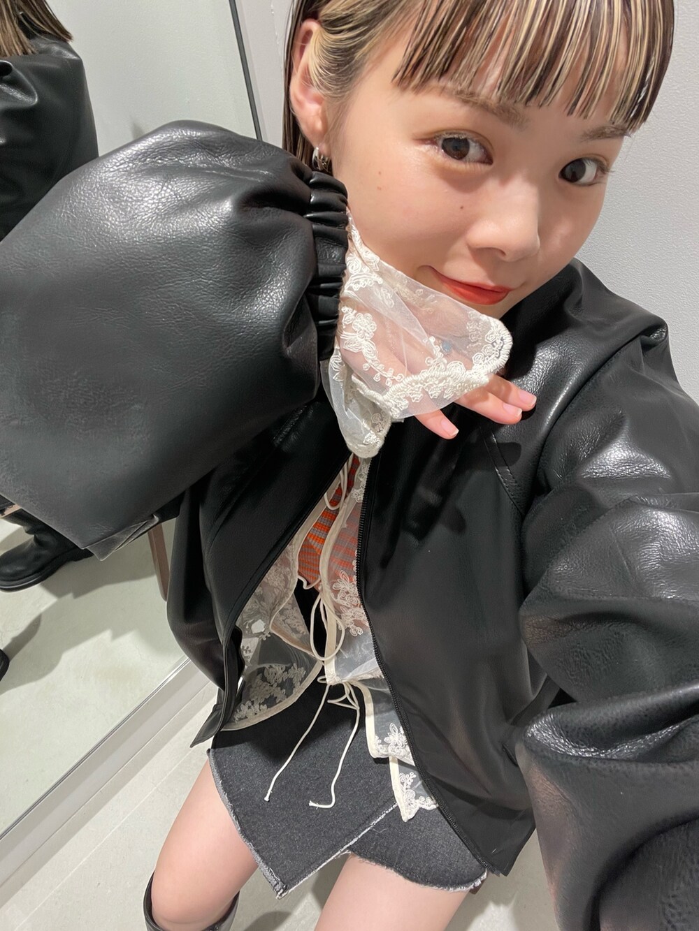 ブラック系のブルゾン、ホワイト系のシャツ/ブラウス、オレンジ系のTシャツ/カットソーを着用したレディースの秋コーディネートの4枚目の写真