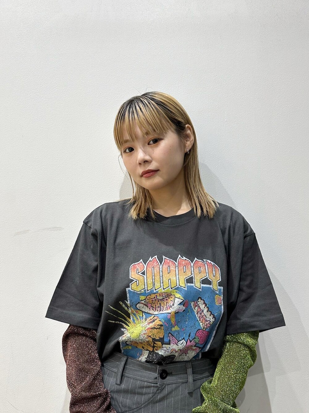 グリーン系のTシャツ/カットソー、グレー系のスラックス、ブルー系のデニムパンツを着用したレディースの夏コーディネートの2枚目の写真