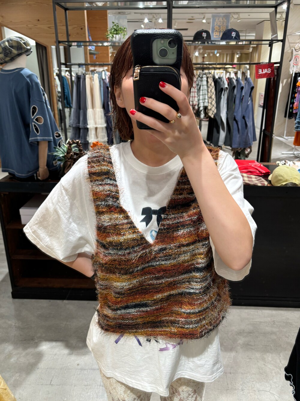 オレンジ系のベスト、ホワイト系のTシャツ/カットソー、ホワイト系のその他パンツを着用したレディースの夏コーディネートの2枚目の写真
