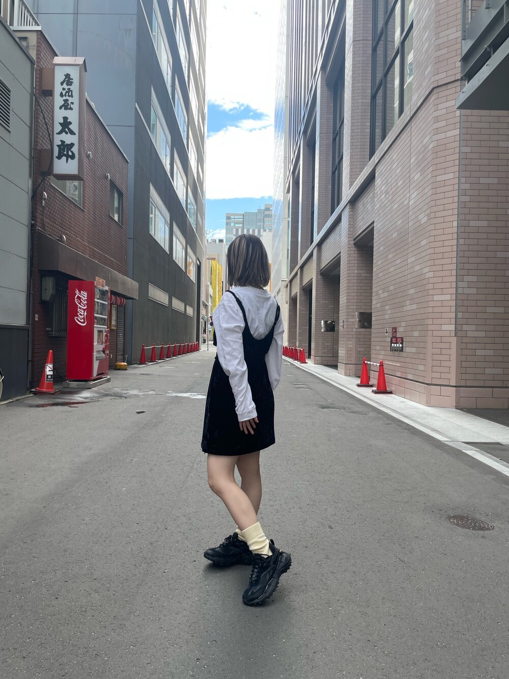 ブラック系のキャミソール、ホワイト系のTシャツ/カットソー、ブラック系のデニムスカートを着用したレディースの秋コーディネートの2枚目の写真