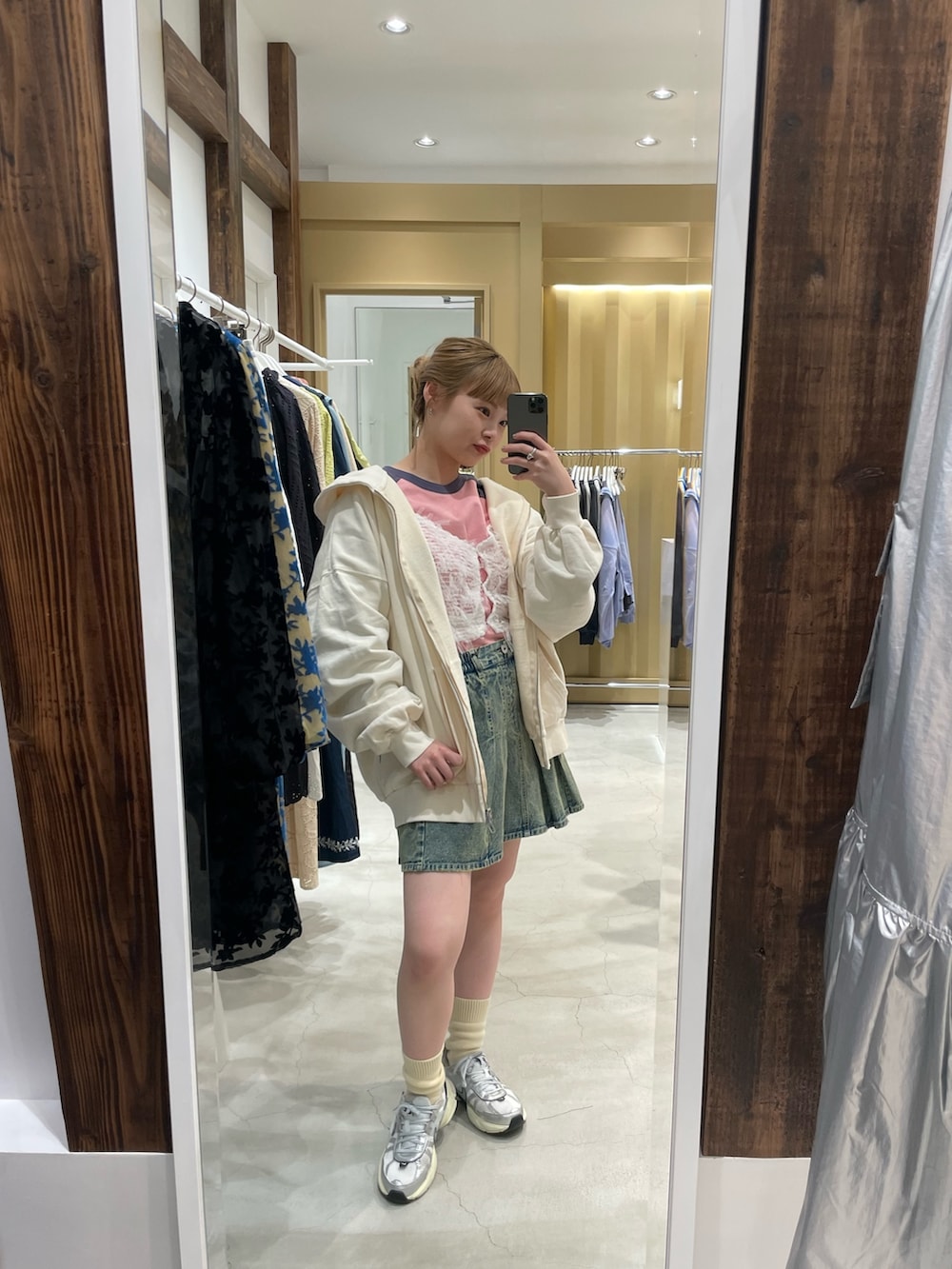 ホワイト系のパーカー、ホワイト系のキャミソール、ブルー系のデニムスカートを着用したレディースの春コーディネートの4枚目の写真