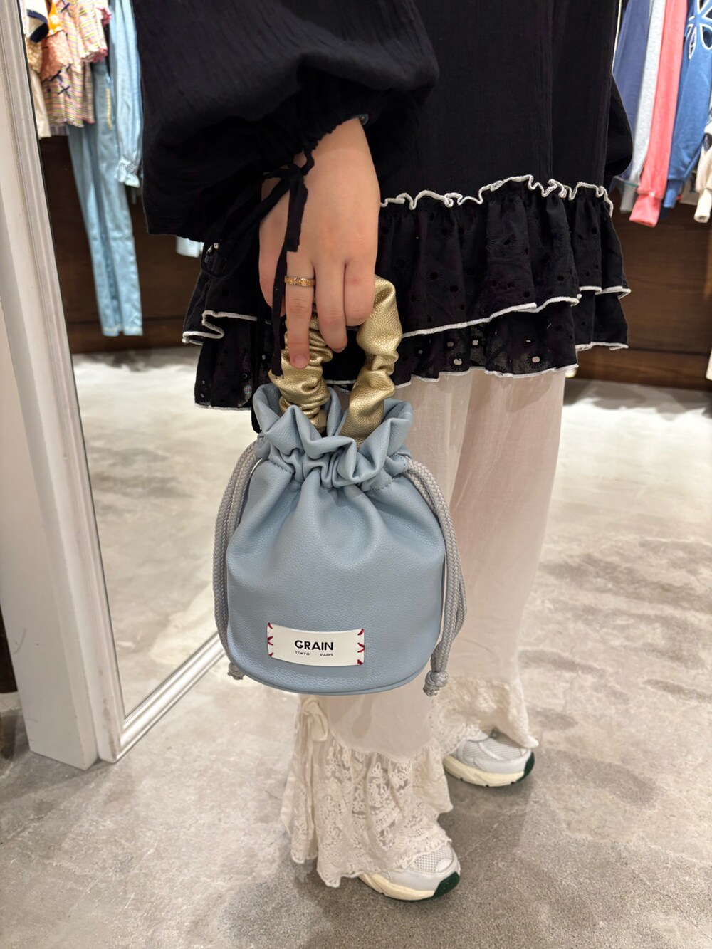ベージュ系のワンピース、ホワイト系のその他パンツ、オレンジ系のハンドバッグを着用したレディースの春コーディネートの3枚目の写真