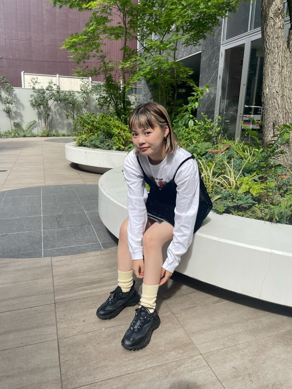 ブラック系のキャミソール、ホワイト系のTシャツ/カットソー、ブラック系のデニムスカートを着用したレディースの秋コーディネートの4枚目の写真