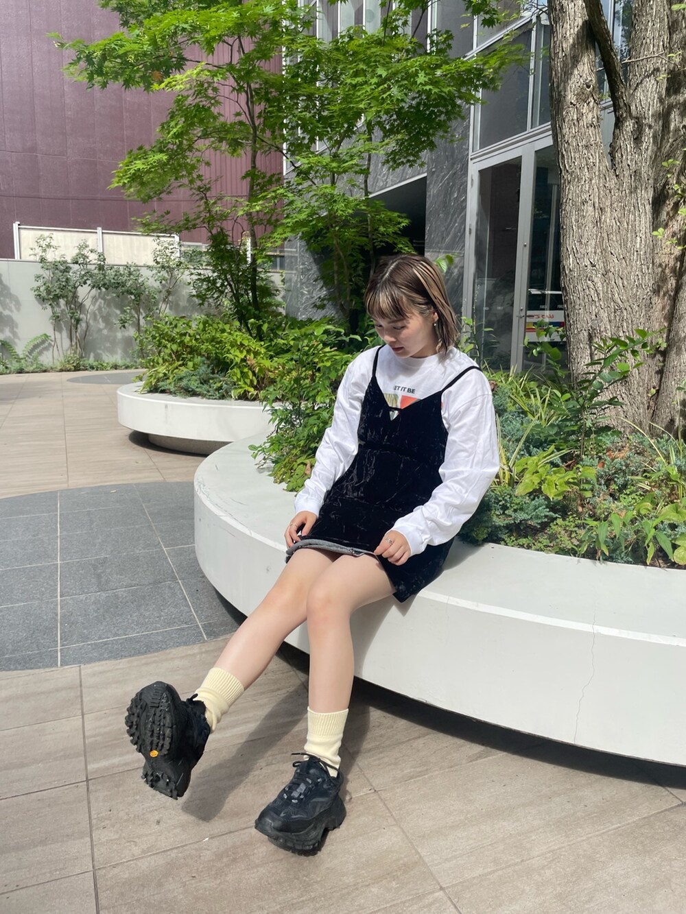 ブラック系のキャミソール、ホワイト系のTシャツ/カットソー、ブラック系のデニムスカートを着用したレディースの秋コーディネートの5枚目の写真